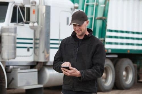 Man using phone by semi truck