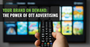 A hand holding a remote in front of a TV